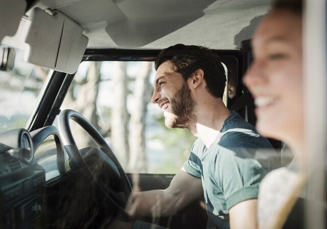 Couple smiling in car for vacation